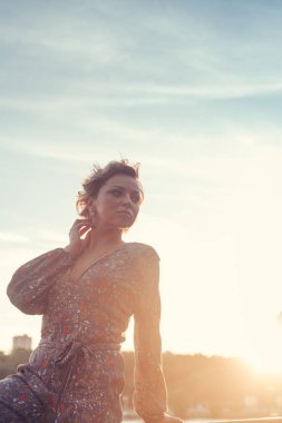 Sıcak yaz gününde Sunset'teki bir parkta kameraya poz kadın