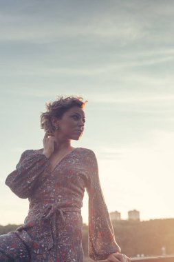 Sıcak yaz gününde Sunset'teki kameraya poz kadın