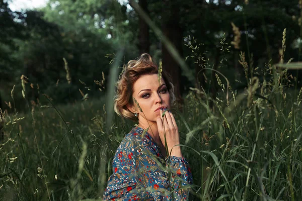 Close up portrait of a mysterious woman in a field on a warm summer day