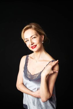 Stüdyo portre siyah arka plan karşı bir ipek elbise içinde güzel kadın kapatmak