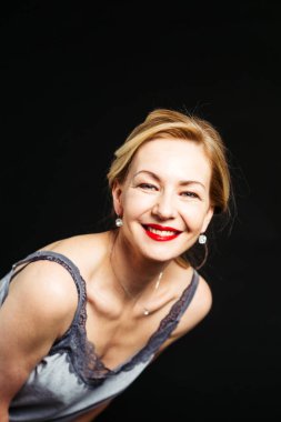 Stüdyo portre siyah arka plan karşı bir ipek elbise içinde güzel kadın kapatmak