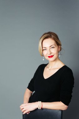 Gri arka plan siyah elbiseli güzel kadın portresi