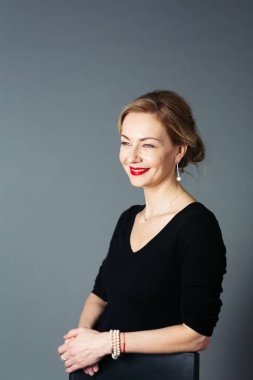Gri arka plan siyah elbiseli güzel kadın portresi