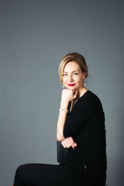 Gri arka plan siyah elbiseli güzel kadın portresi