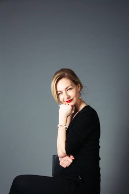 Gri arka plan siyah elbiseli güzel kadın portresi