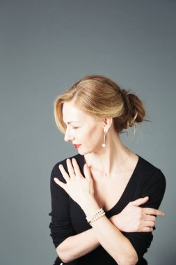 Gri arka plan siyah elbiseli güzel kadın portresi