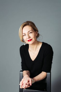 Gri arka plan siyah elbiseli güzel kadın portresi