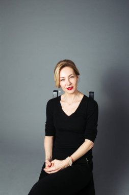 Gri arka plan siyah elbiseli güzel kadın portresi