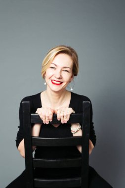 Gri arka plan siyah elbiseli güzel kadın portresi