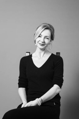 Gri arka plan siyah elbiseli güzel kadın portresi