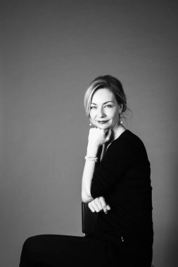 Gri arka plan siyah elbiseli güzel kadın portresi