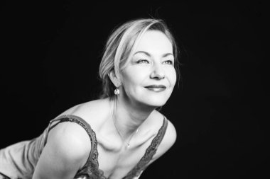 Stüdyo portre siyah arka plan karşı bir ipek elbise içinde güzel kadın kapatmak