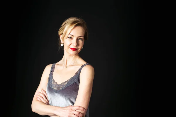 Stüdyo portre siyah arka plan karşı bir ipek elbise içinde güzel kadın kapatmak