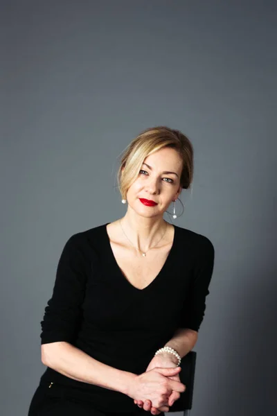 Gri arka plan siyah elbiseli güzel kadın portresi