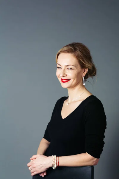 Gri arka plan siyah elbiseli güzel kadın portresi