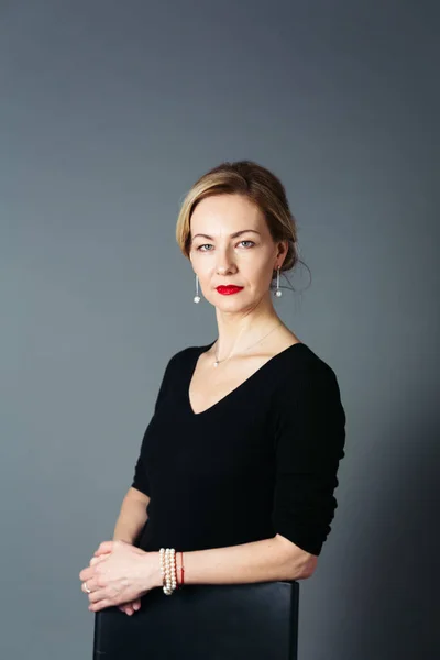 Gri arka plan siyah elbiseli güzel kadın portresi