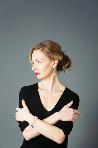 Gri arka plan siyah elbiseli güzel kadın portresi