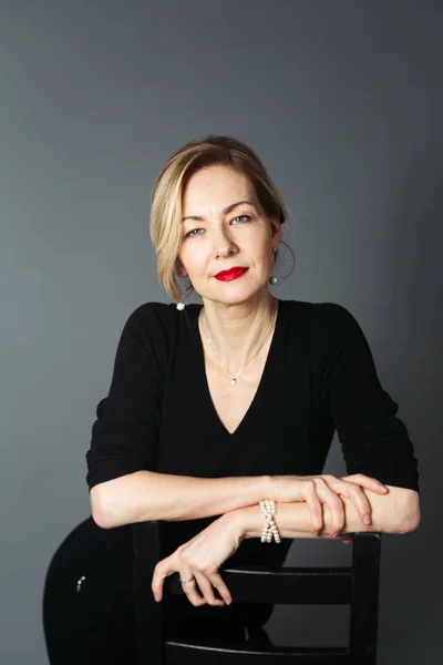 Gri arka plan siyah elbiseli güzel kadın portresi