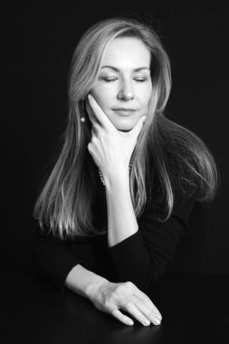 Gözleri kapalı, siyah arka plan üzerinde siyah elbiseli güzel bir kadın portresi studio kapatın