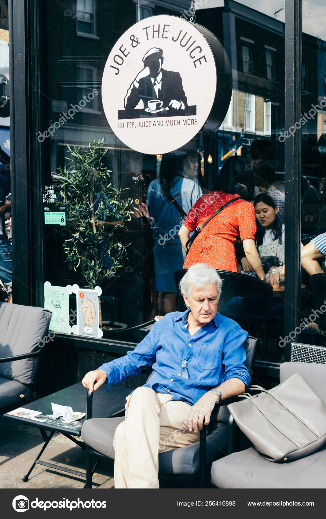 Elderly Man Resting In A Chair In The Street Cafe Stock