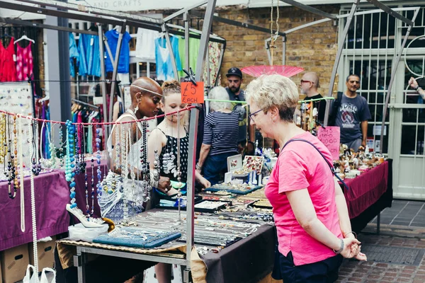 İndirimdeki el yapımı mücevherlere bakan bir kadın.