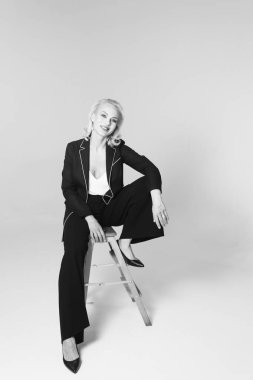 Siyah bir elbiseyle sarışın bir kadının portresi