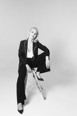 Siyah bir elbiseyle sarışın bir kadının portresi