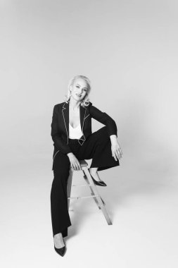 Siyah bir elbiseyle sarışın bir kadının portresi