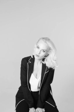 Siyah bir elbiseyle sarışın bir kadının portresi