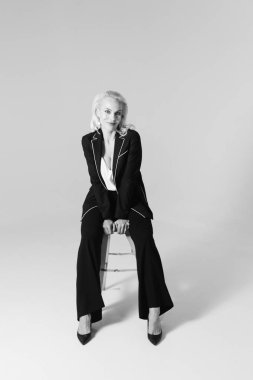 Siyah bir elbiseyle sarışın bir kadının portresi