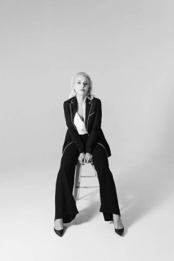 Siyah bir elbiseyle sarışın bir kadının portresi