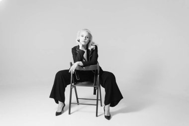 Siyah bir elbiseyle sarışın bir kadının portresi