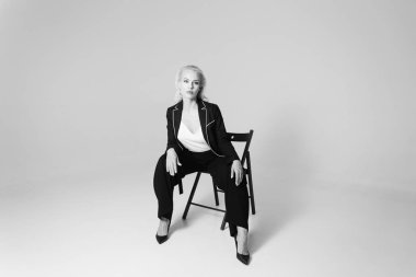 Siyah bir elbiseyle sarışın bir kadının portresi