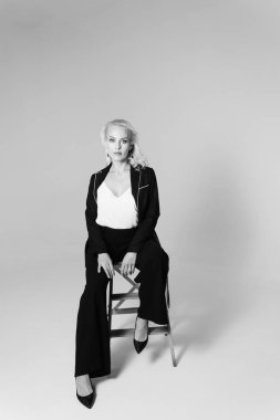 Siyah bir elbiseyle sarışın bir kadının portresi