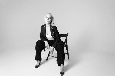 Siyah bir elbiseyle sarışın bir kadının portresi