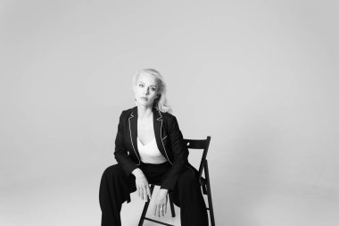 Siyah bir elbiseyle sarışın bir kadının portresi