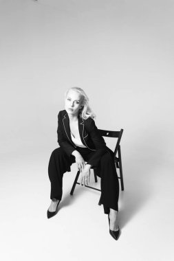 Siyah bir elbiseyle sarışın bir kadının portresi