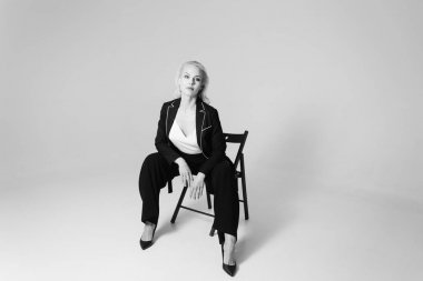 Siyah bir elbiseyle sarışın bir kadının portresi