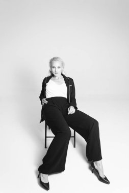 Siyah bir elbiseyle sarışın bir kadının portresi