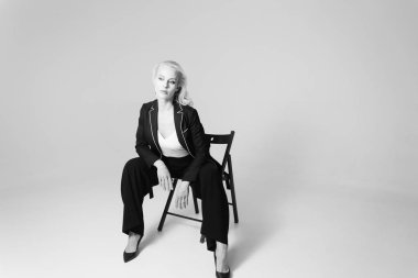 Siyah bir elbiseyle sarışın bir kadının portresi