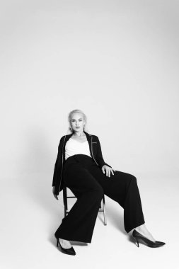 Siyah bir elbiseyle sarışın bir kadının portresi