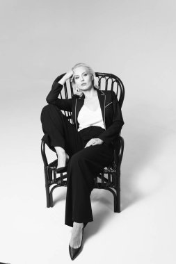 Siyah bir elbiseyle sarışın bir kadının portresi