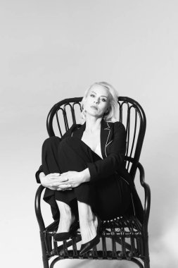 Siyah bir elbiseyle sarışın bir kadının portresi