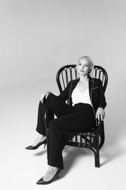 Siyah bir elbiseyle sarışın bir kadının portresi