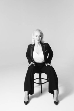 Siyah bir elbiseyle sarışın bir kadının portresi