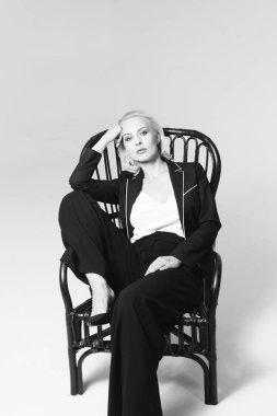 Siyah bir elbiseyle sarışın bir kadının portresi