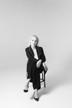 Siyah bir elbiseyle sarışın bir kadının portresi