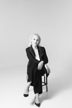 Siyah bir elbiseyle sarışın bir kadının portresi