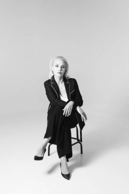 Siyah bir elbiseyle sarışın bir kadının portresi