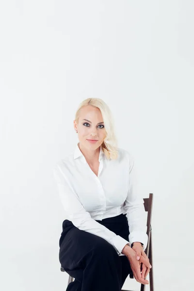 Πορτρέτο μιας ξανθιάς γυναίκα με ένα λευκό πουκάμισο και μαύρο παντελόνι — Φωτογραφία Αρχείου